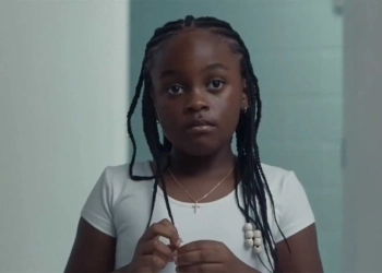 Gambar dari film On a Sunday at Eleven, tampak seorang anak berkulit hitam mengenakan kaos putih.