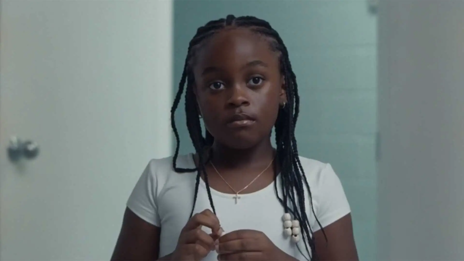 Gambar dari film On a Sunday at Eleven, tampak seorang anak berkulit hitam mengenakan kaos putih.